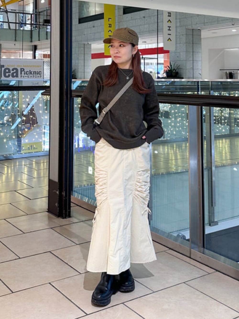 グレー系のTシャツ/カットソー、グレー系のトートバッグ、ホワイト系のスカートを着用したレディースの冬コーディネートの1枚目の写真