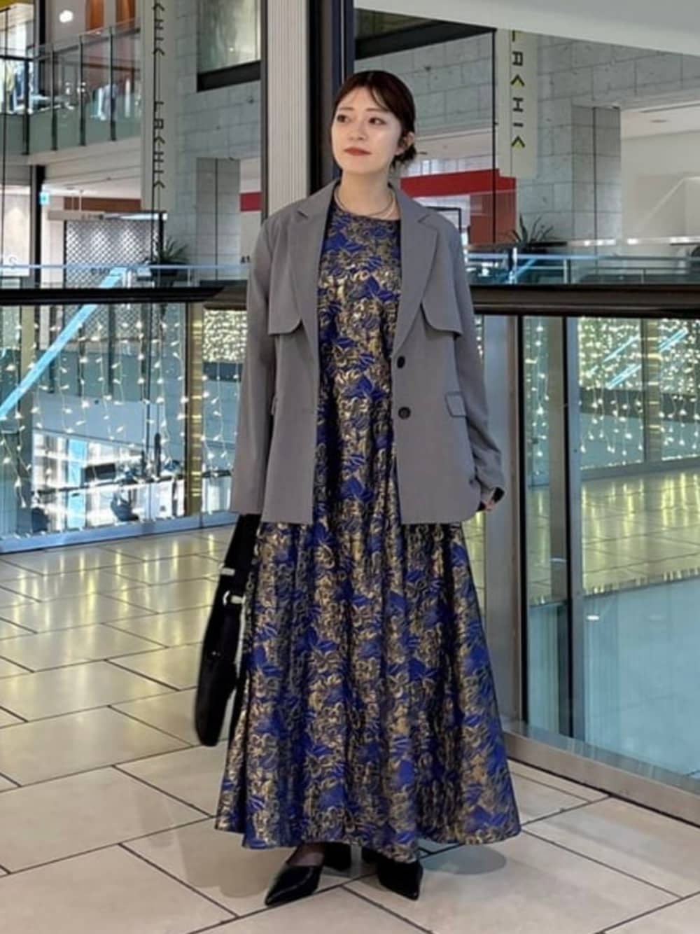 シルバー系のテーラードジャケット、ブラック系のパンプスを着用したレディースの冬コーディネートの1枚目の写真