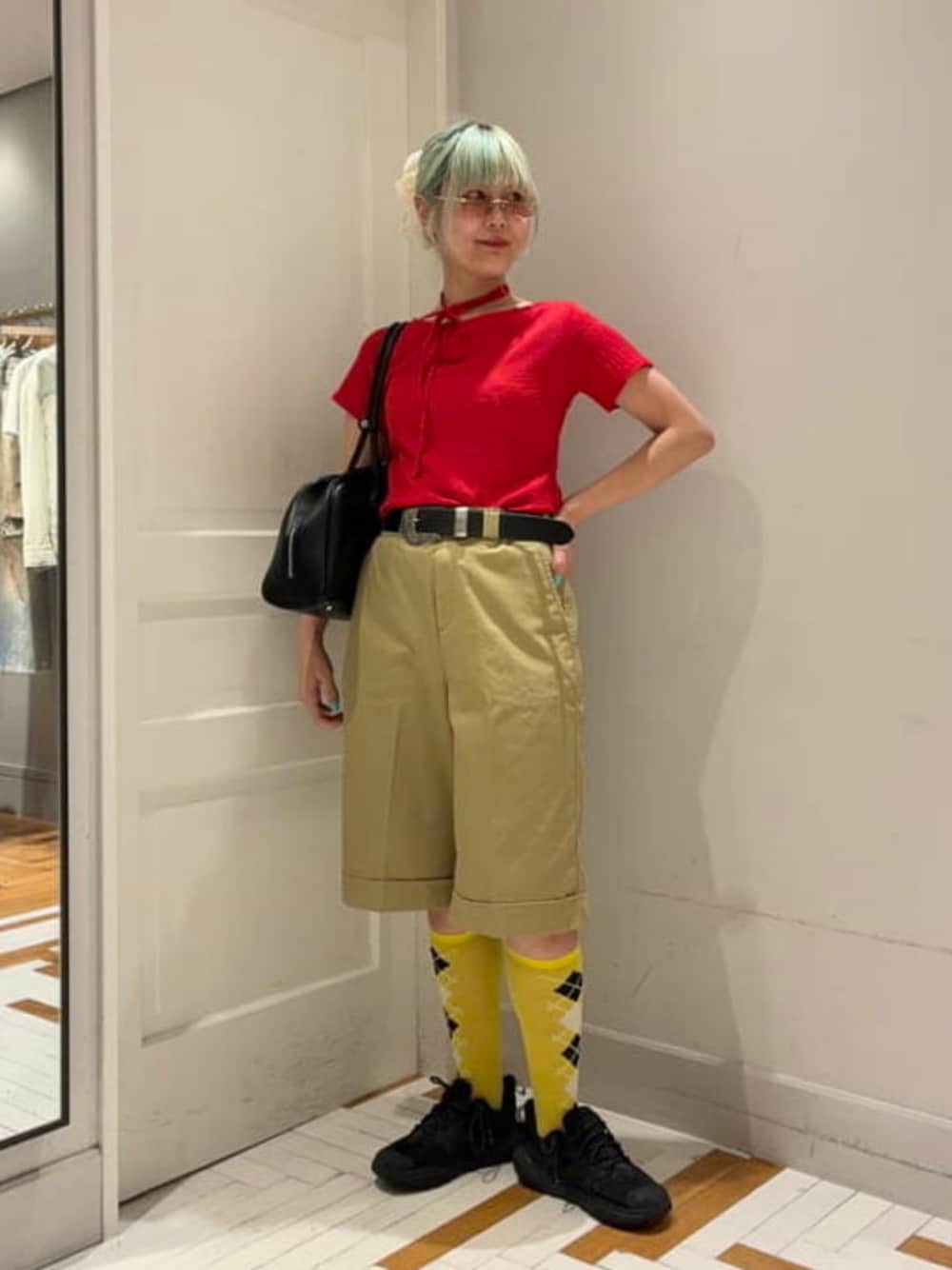 グリーン系のチノパンツ、レッド系のTシャツ/カットソー、ゴールド系のサングラスを着用したレディースの夏コーディネートの1枚目の写真