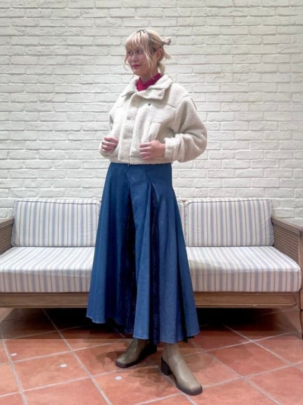 グリーン系のブーツ、ホワイト系のブルゾン、レッド系のTシャツ/カットソーを着用したレディースの秋コーディネートの1枚目の写真