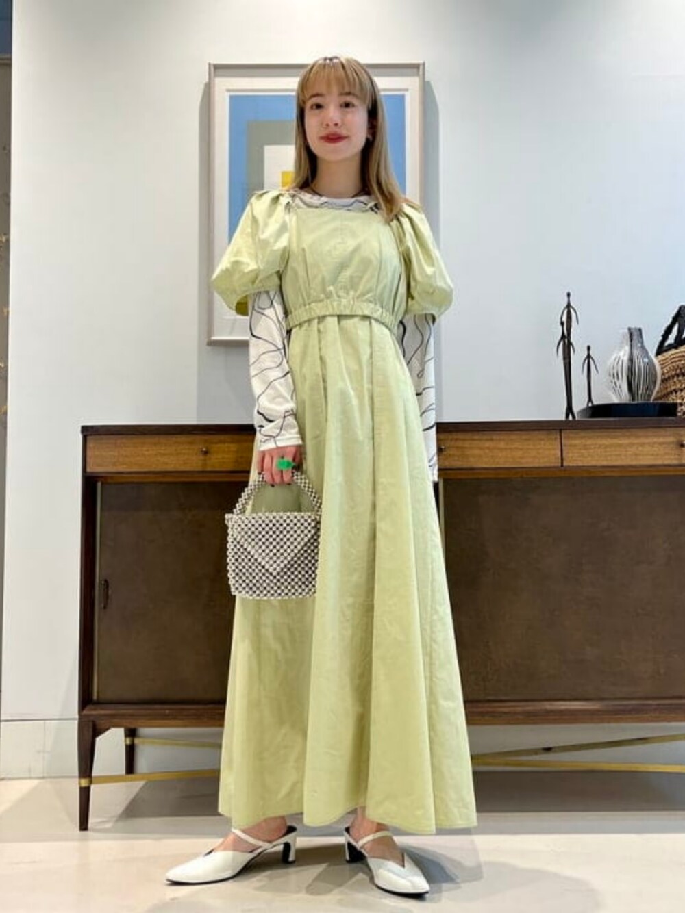 グリーン系のワンピースを着用したレディースの冬コーディネートの1枚目の写真