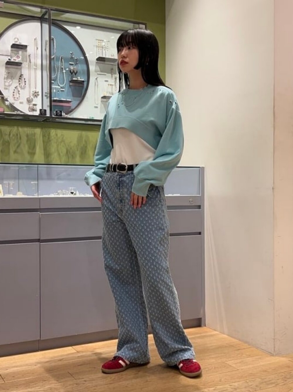 ホワイト系のタンクトップ、ブルー系のデニムパンツ、ブルー系のスウェットを着用したレディースの冬コーディネートの1枚目の写真