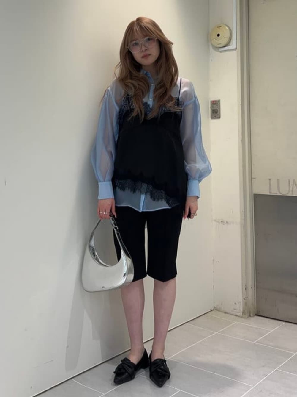 シルバー系のトートバッグ、ブラック系のその他パンツ、ブルー系のシャツ/ブラウスを着用したレディースの春コーディネートの1枚目の写真