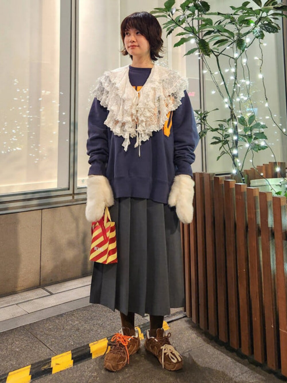 グレー系のスカート、ホワイト系の手袋を着用したレディースの冬コーディネートの1枚目の写真