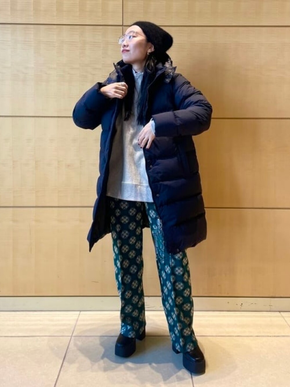 グレー系のスウェット、ブラック系のダウンジャケット/コート、ブラック系のブーツを着用したレディースの秋コーディネートの1枚目の写真