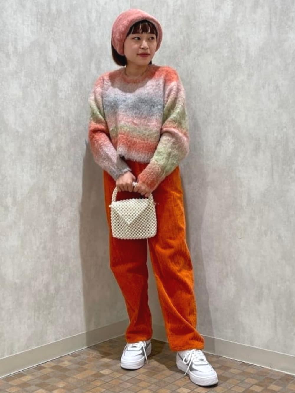 ホワイト系のメッセンジャーバッグ、オレンジ系のその他パンツ、ホワイト系のスニーカーを着用したレディースの秋コーディネートの1枚目の写真