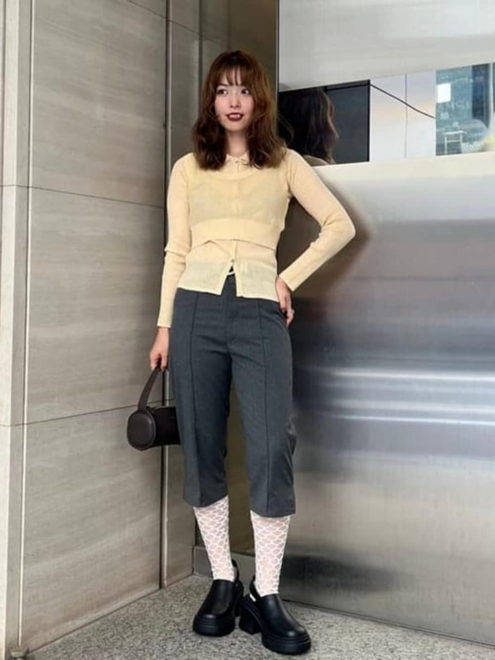 ベージュ系のニット/セーター、ブラウン系のトートバッグ、グレー系のその他パンツを着用したレディースの秋コーディネートの1枚目の写真