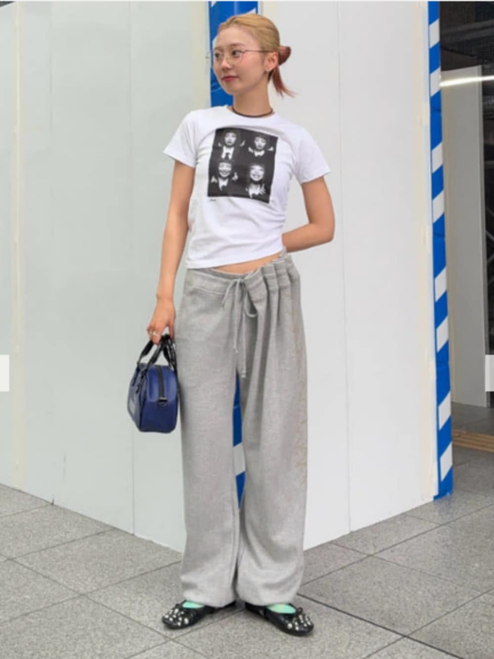 ブルー系のハンドバッグ、ホワイト系のTシャツ/カットソーを着用したレディースの夏コーディネートの1枚目の写真