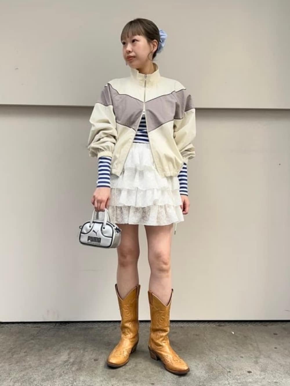 ホワイト系のナイロンジャケット、シルバー系のショルダーバッグを着用したレディースの春コーディネートの1枚目の写真