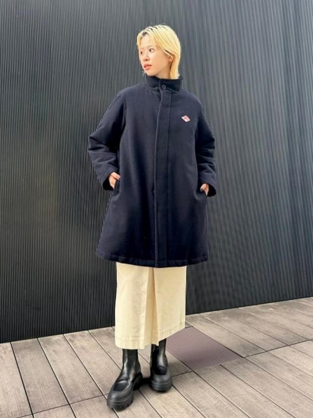 ブルー系のダウンジャケット/コート、ホワイト系のスカート、ブラック系のブーツを着用したレディースの秋コーディネートの1枚目の写真