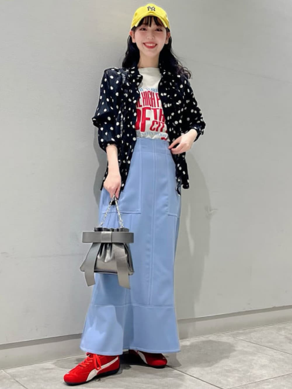 ブラック系のショルダーバッグ、ブラック系のシャツ/ブラウス、ブルー系のスカートを着用したレディースの冬コーディネートの1枚目の写真