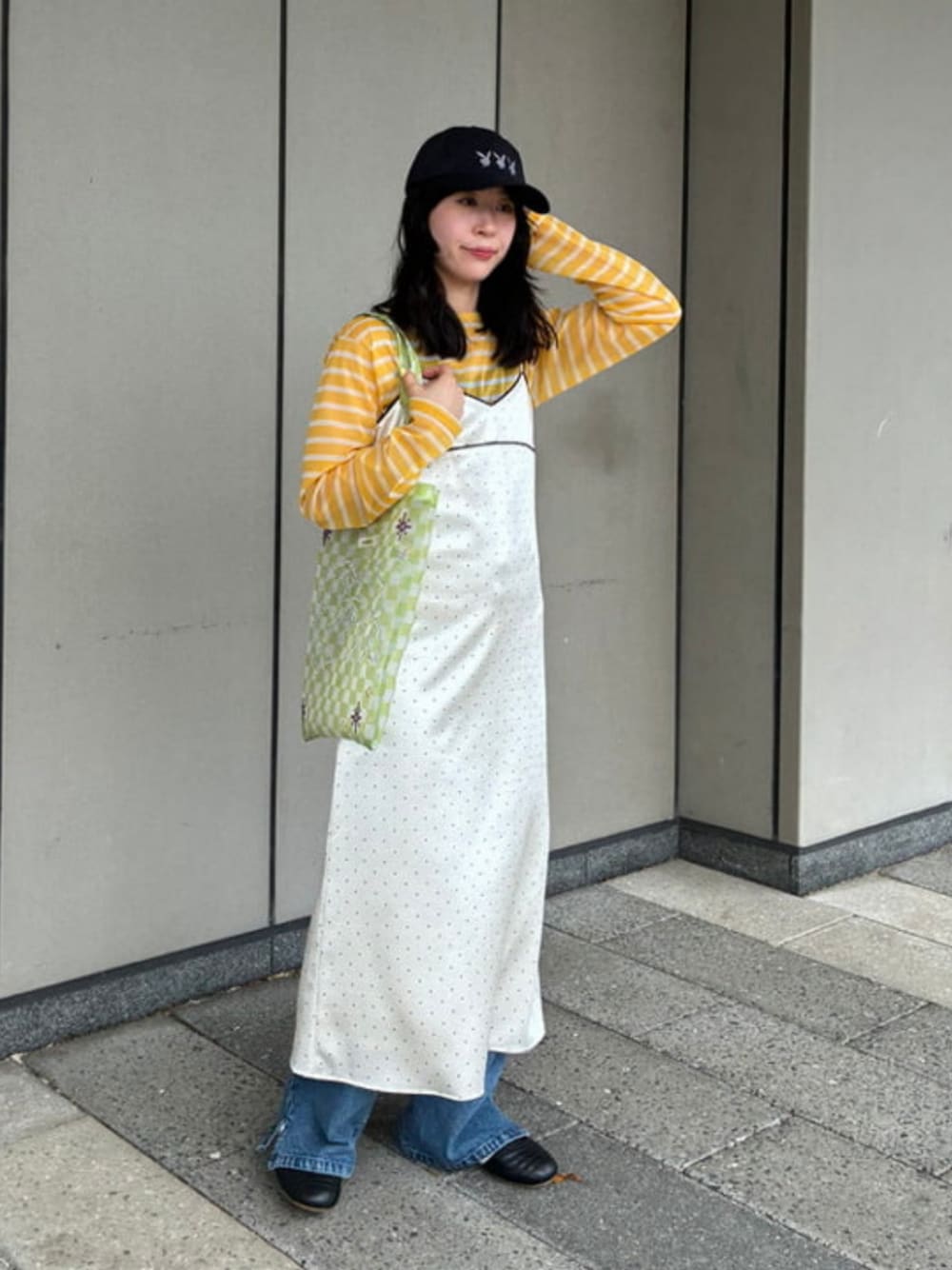 イエロー系のTシャツ/カットソー、ホワイト系のワンピース、ブラック系のスニーカーを着用したレディースの春コーディネートの1枚目の写真