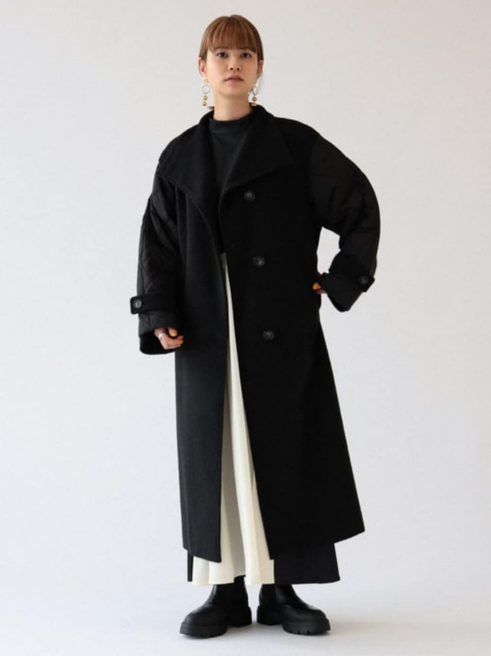 ブラック系のワンピース、ブラック系のその他アウター、ゴールド系のピアス(両耳用)を着用したレディースの秋コーディネートの1枚目の写真