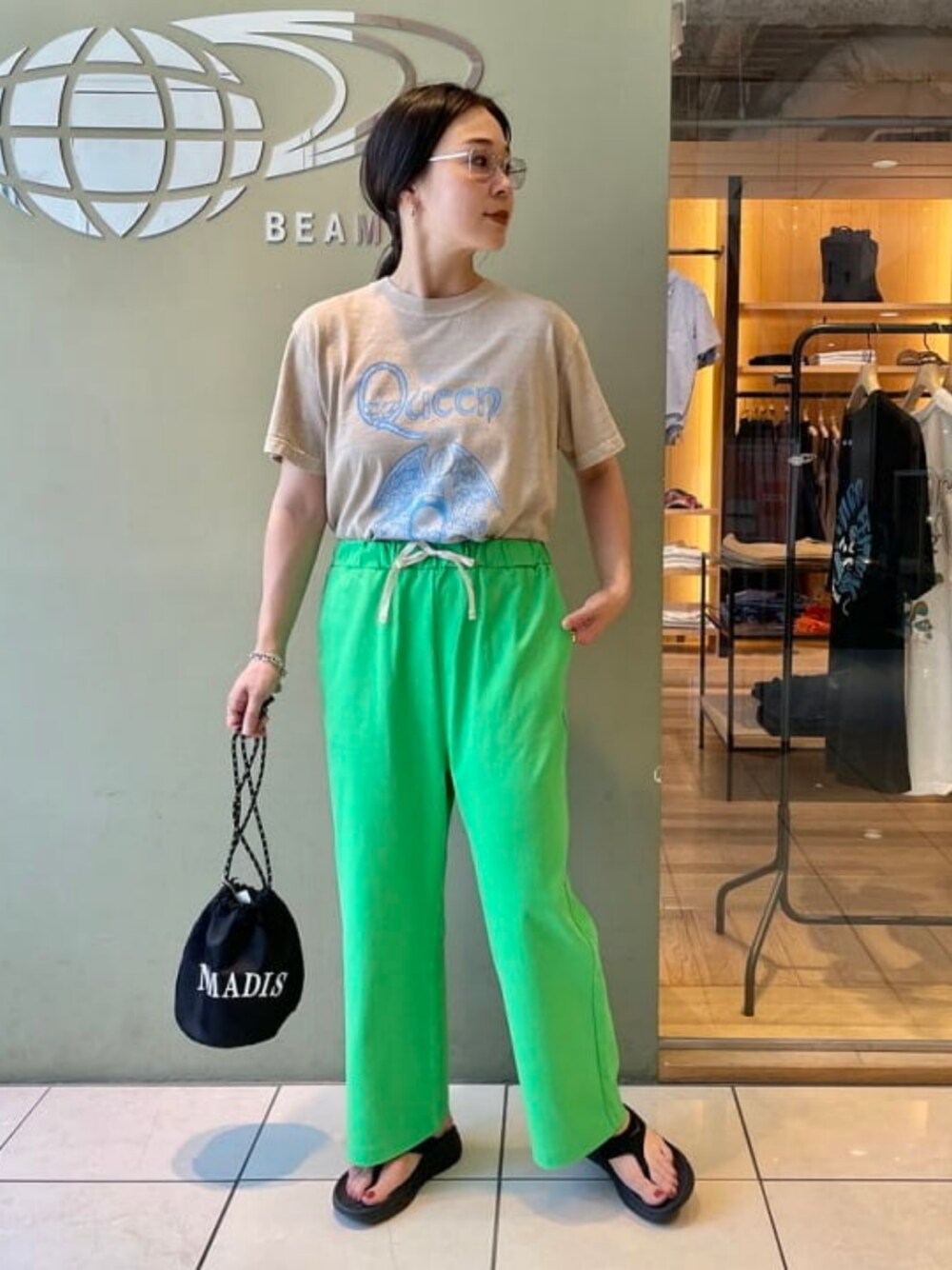 ベージュ系のTシャツ/カットソー、グリーン系のスウェットパンツ、ブラック系のショルダーバッグを着用したレディースの夏コーディネートの1枚目の写真