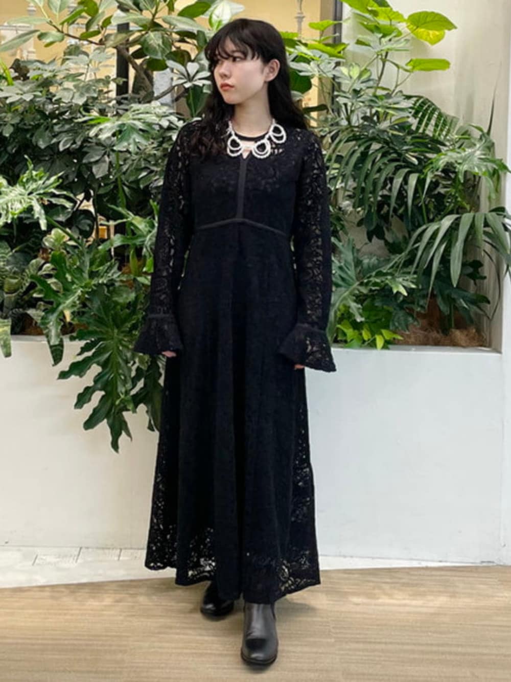 ブラック系のブーツ、ブラック系のワンピース、ホワイト系のネックレスを着用したレディースの冬コーディネートの1枚目の写真