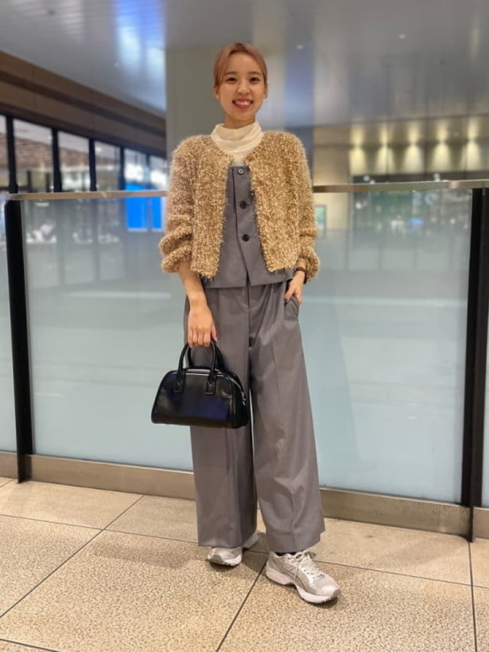 シルバー系のサロペット/オーバーオール、ブラック系のボストンバッグ、グリーン系のカーディガン/ボレロを着用したレディースの秋コーディネートの1枚目の写真