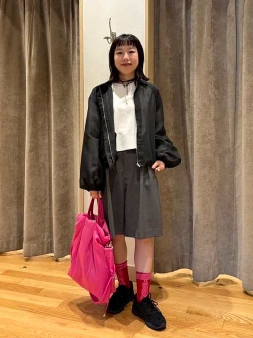 レッド系のトートバッグ、ホワイト系のTシャツ/カットソー、ブラック系のブルゾンを着用したレディースの春コーディネートの1枚目の写真