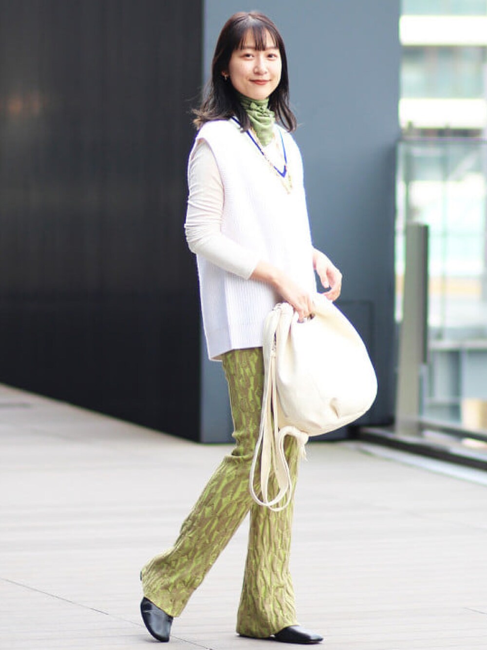 ホワイト系のベスト、グリーン系のその他パンツ、ブラック系のブーツを着用したレディースの夏コーディネートの1枚目の写真