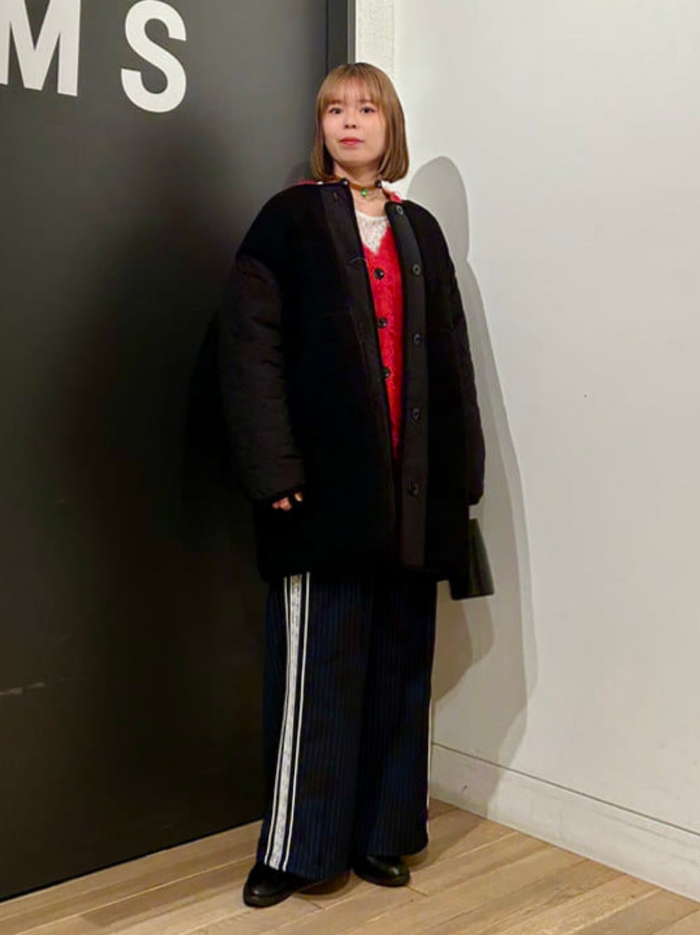 ホワイト系のTシャツ/カットソー、レッド系のカーディガン/ボレロ、ブラック系のノーカラーコートを着用したレディースの冬コーディネートの1枚目の写真