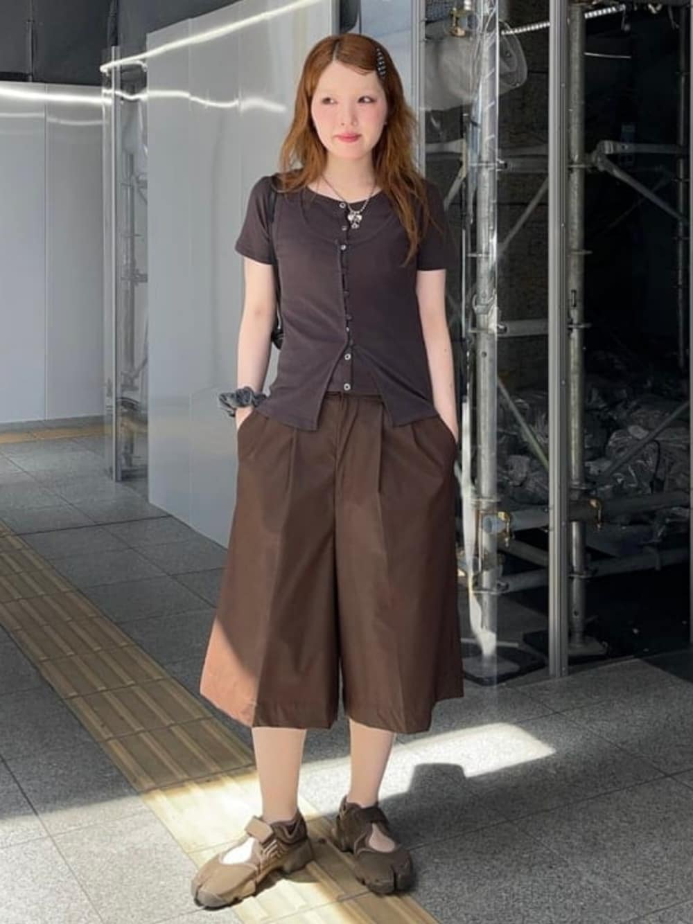 ブラック系のトートバッグ、ブラウン系のTシャツ/カットソー、ブラウン系のその他パンツを着用したレディースの夏コーディネートの1枚目の写真