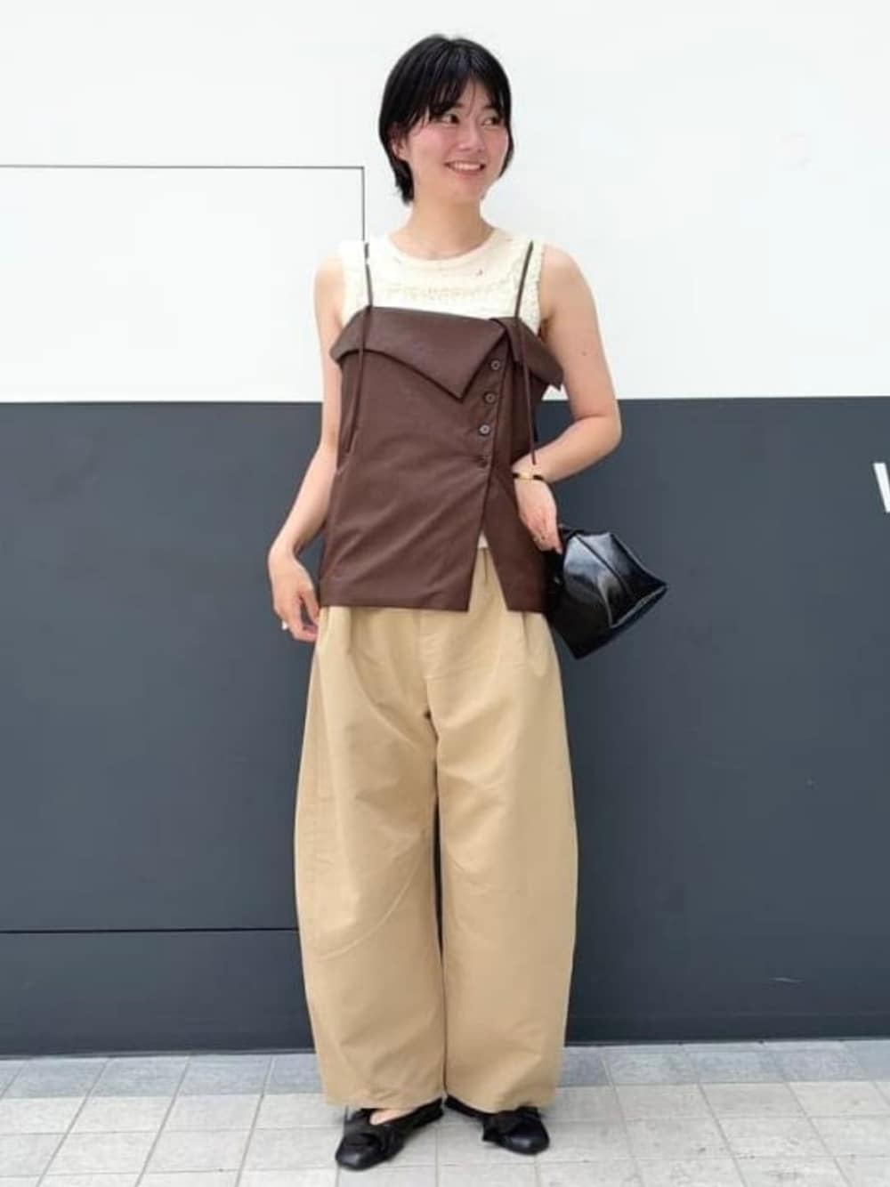 ブラック系のショルダーバッグ、グリーン系のチノパンツ、ホワイト系のシャツ/ブラウスを着用したレディースの夏コーディネートの1枚目の写真
