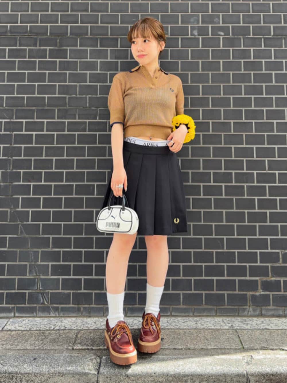 ブラック系のその他パンツ、ブラウン系のポロシャツ、ホワイト系のショルダーバッグを着用したレディースの春コーディネートの1枚目の写真