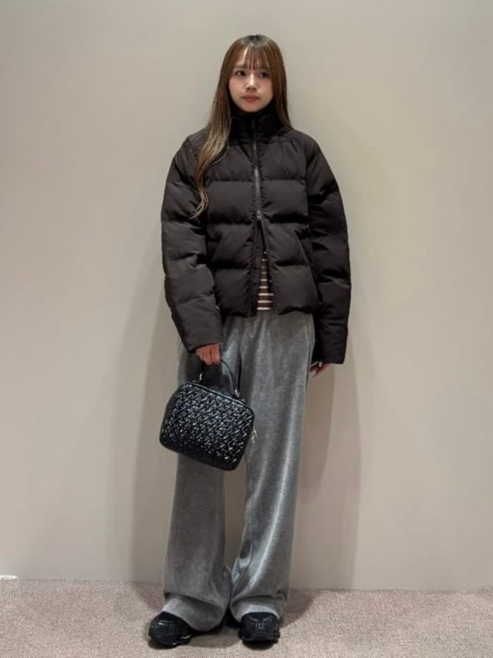 ブラック系のハンドバッグ、グレー系のその他パンツ、ブラウン系のブルゾンを着用したレディースの秋コーディネートの1枚目の写真