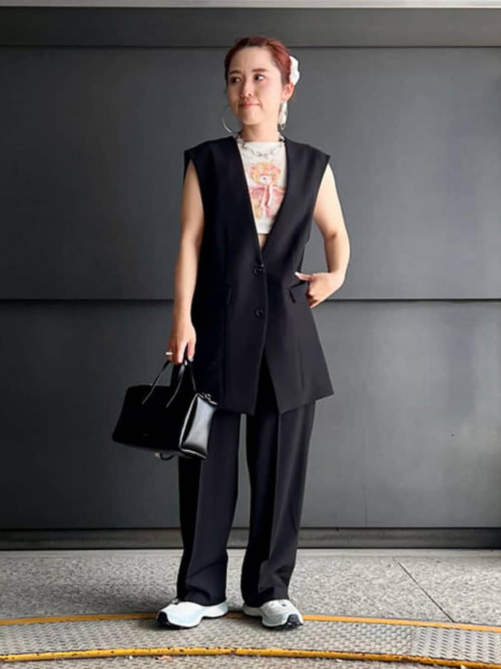 ブラック系のベスト、ブラック系のスラックス、ブラック系のトートバッグを着用したレディースの夏コーディネートの1枚目の写真