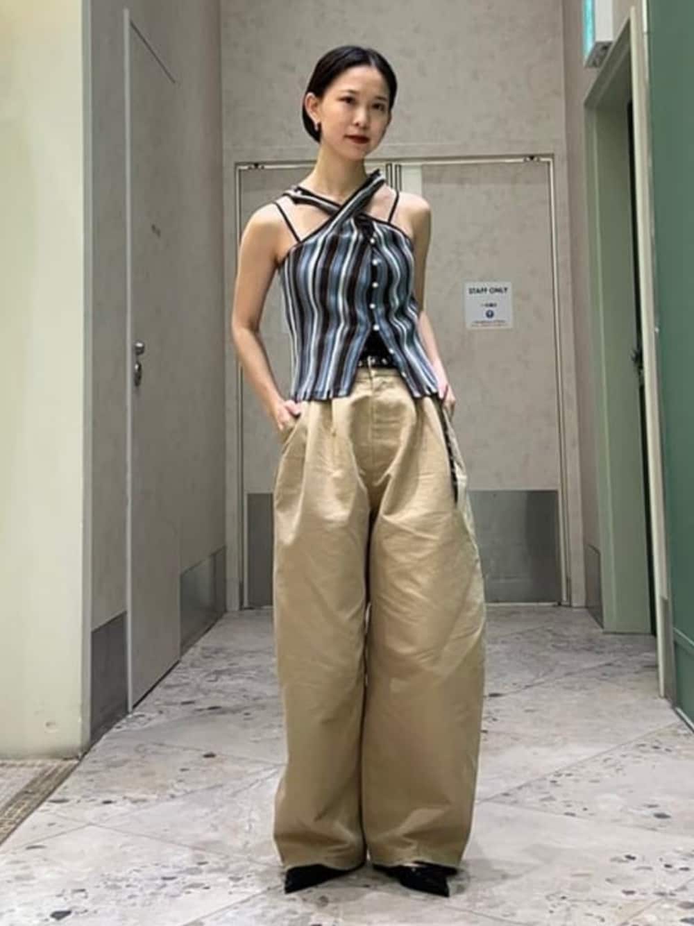 グリーン系のチノパンツ、ブルー系のキャミソール、ブラック系のキャミソールを着用したレディースの春コーディネートの1枚目の写真