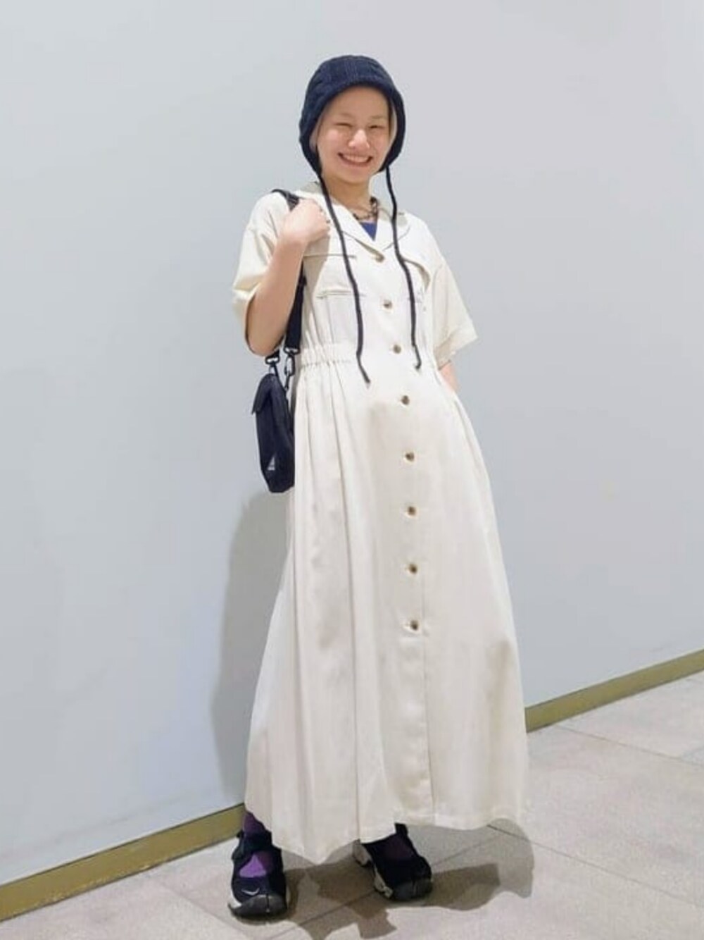 ホワイト系のワンピース、ブラック系のショルダーバッグ、ブラック系のハットを着用したレディースの春コーディネートの1枚目の写真