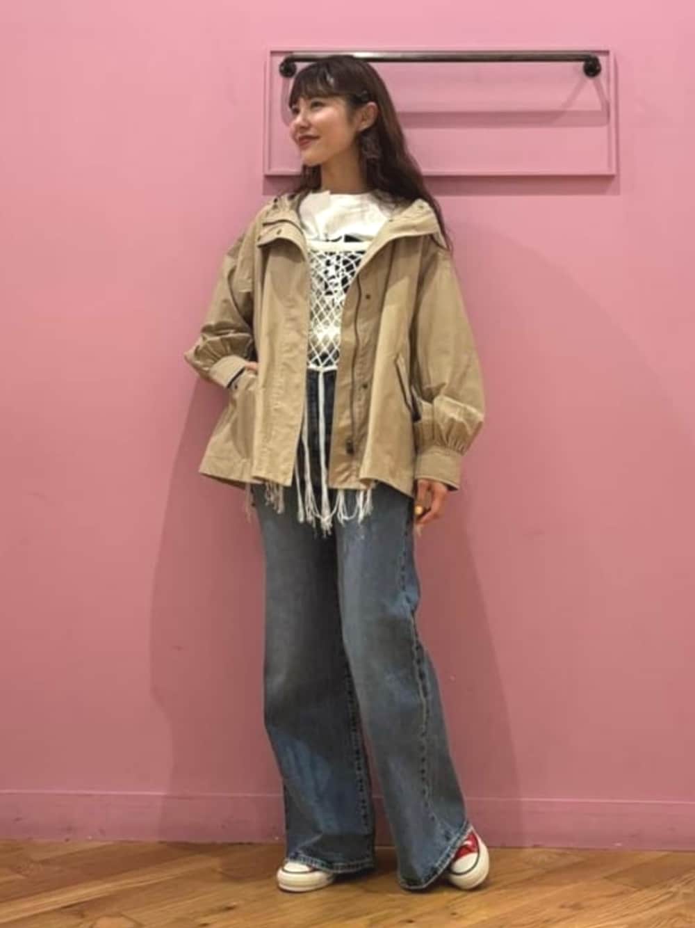 ベージュ系のマウンテンパーカー、ホワイト系のニット/セーター、ブルー系のデニムパンツを着用したレディースの春コーディネートの1枚目の写真