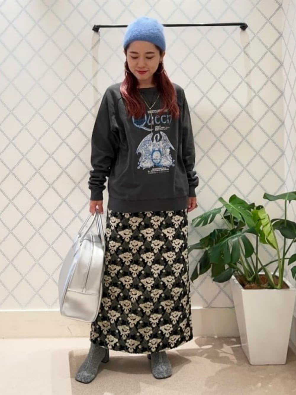 シルバー系のボストンバッグ、グレー系のスカート、シルバー系のブーツを着用したレディースの秋コーディネートの1枚目の写真