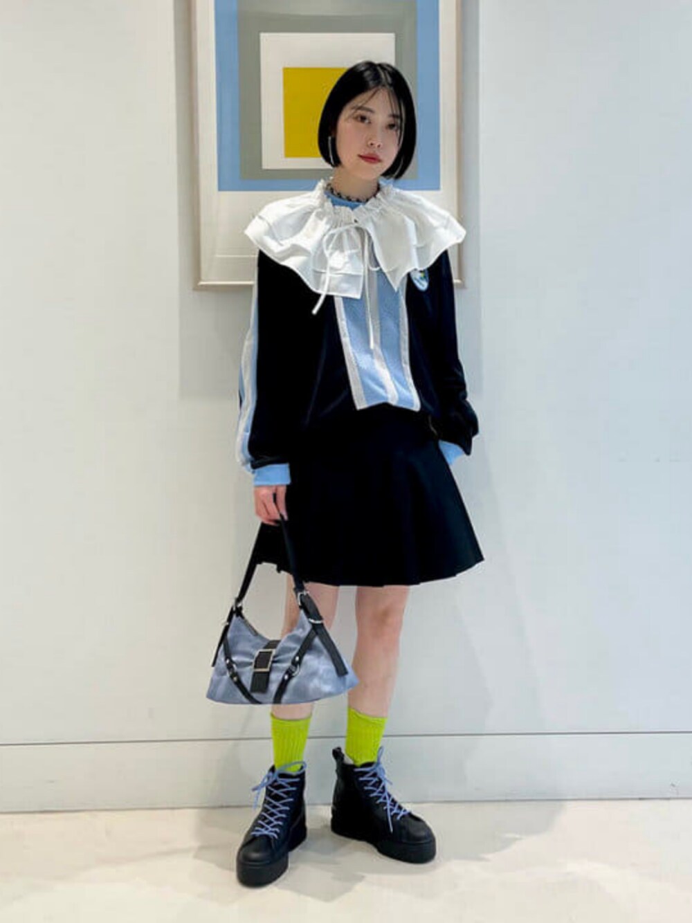 ブラック系のスカート、ブラック系のスニーカー、イエロー系のソックス/靴下を着用したレディースの春コーディネートの1枚目の写真