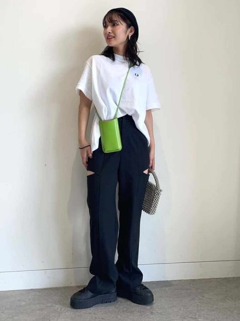 ホワイト系のTシャツ/カットソー、ブラック系のスニーカー、グリーン系のスマホケース/カバーを着用したレディースの冬コーディネートの1枚目の写真