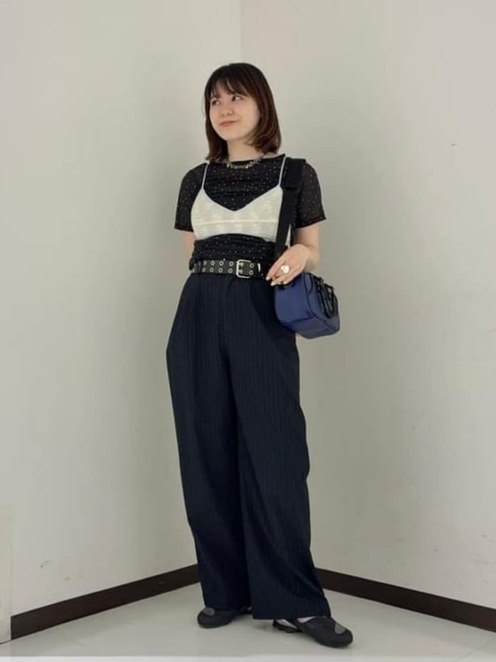 ブルー系のハンドバッグ、ブラック系のスニーカー、ブラック系のTシャツ/カットソーを着用したレディースの夏コーディネートの1枚目の写真