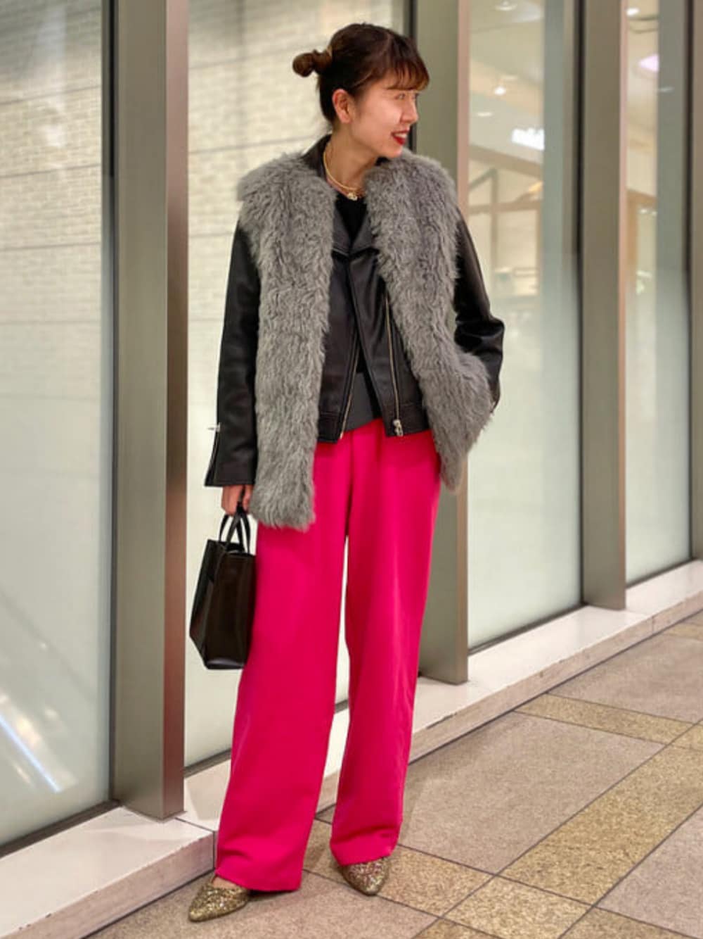 シルバー系のベスト、ブラック系のトートバッグ、ブラック系のライダースジャケットを着用したレディースの秋コーディネートの1枚目の写真