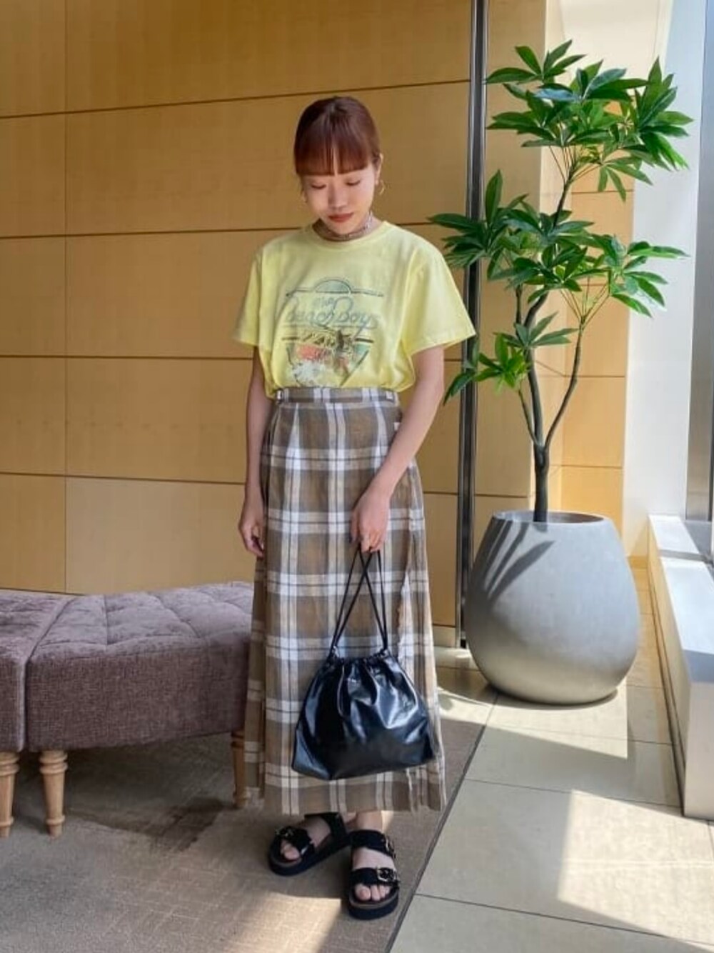 ベージュ系のTシャツ/カットソー、ブラック系のサンダルを着用したレディースの夏コーディネートの1枚目の写真