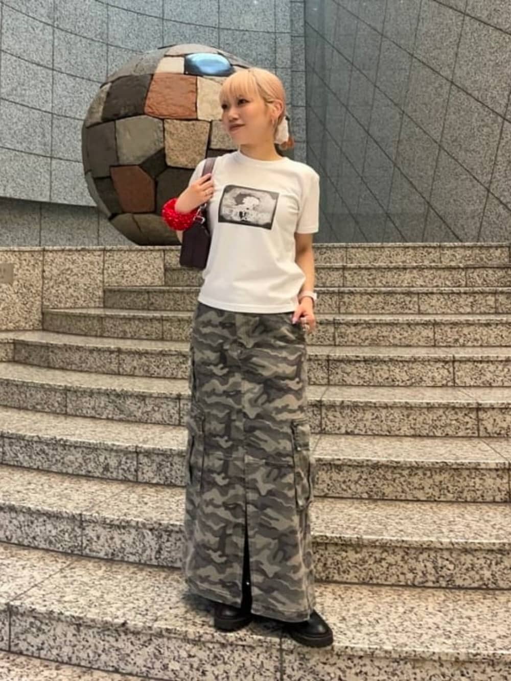 ホワイト系のTシャツ/カットソー、ブラウン系のトートバッグ、グリーン系のスカートを着用したレディースの夏コーディネートの1枚目の写真