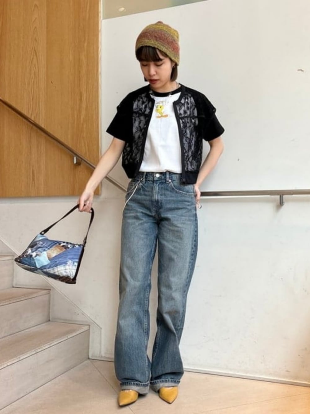 ブラック系のTシャツ/カットソー、ブラック系のベスト、ブラウン系のハンドバッグを着用したレディースの春コーディネートの1枚目の写真