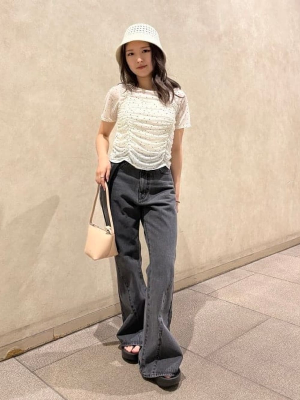 ブラック系のデニムパンツ、ブラック系のサンダル、ホワイト系のTシャツ/カットソーを着用したレディースの夏コーディネートの1枚目の写真