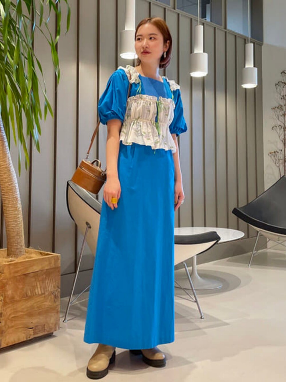 ブルー系のワンピースを着用したレディースの春コーディネートの1枚目の写真