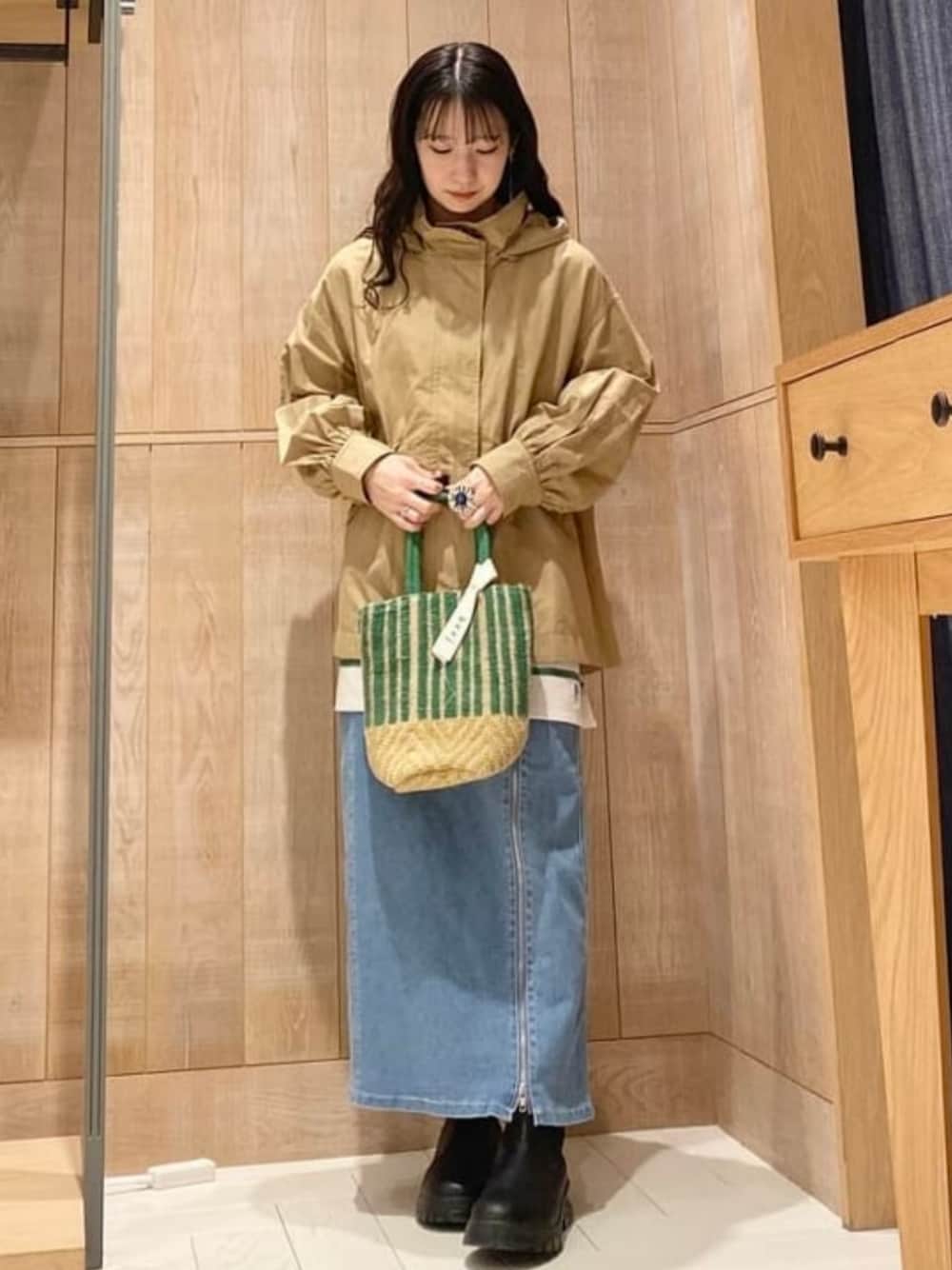 ブルー系のデニムスカート、その他のかごバッグ、ブラウン系のマウンテンパーカーを着用したレディースの春コーディネートの1枚目の写真