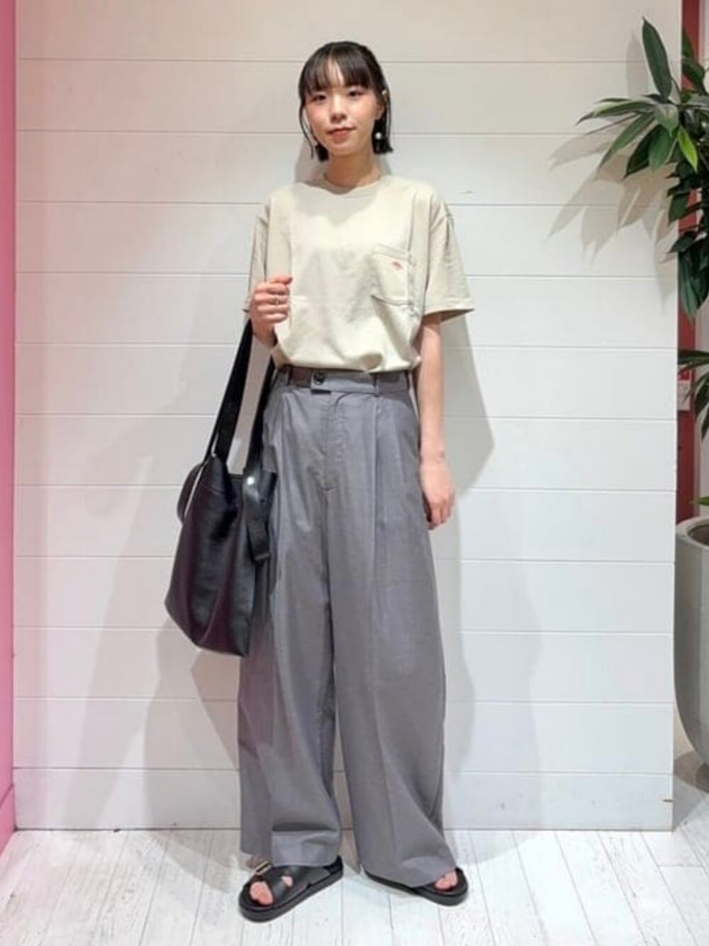 ブラック系のトートバッグ、ブラック系のサンダル、ベージュ系のTシャツ/カットソーを着用したレディースの夏コーディネートの1枚目の写真