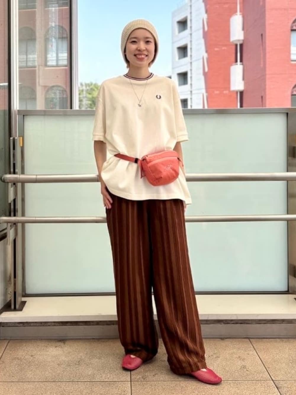 ベージュ系のTシャツ/カットソー、ブラウン系のその他パンツ、レッド系のボディバッグ/ウエストポーチを着用したレディースの夏コーディネートの1枚目の写真