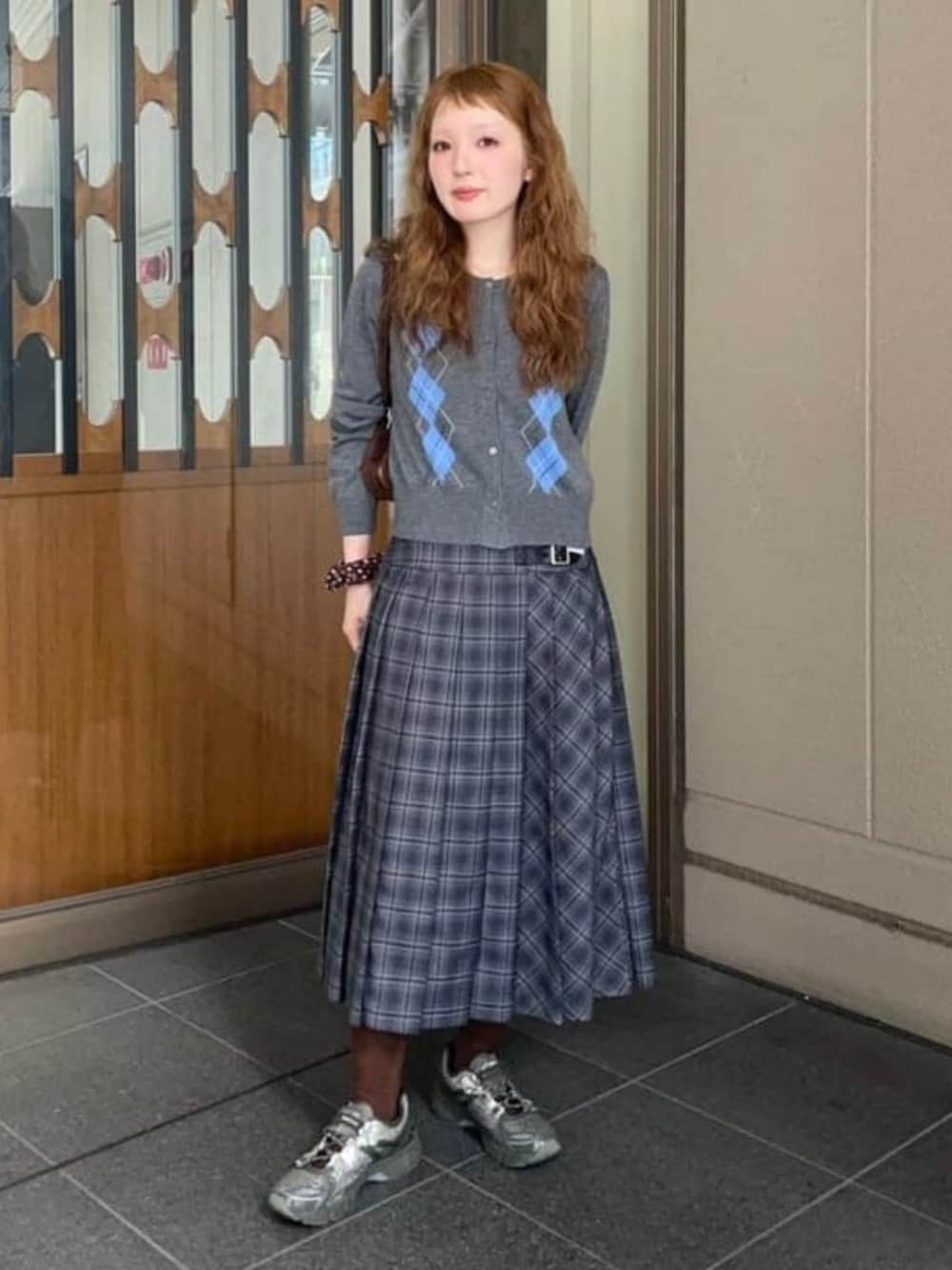 シルバー系のカーディガン/ボレロ、シルバー系のスカート、ブラウン系のトートバッグを着用したレディースの秋コーディネートの1枚目の写真