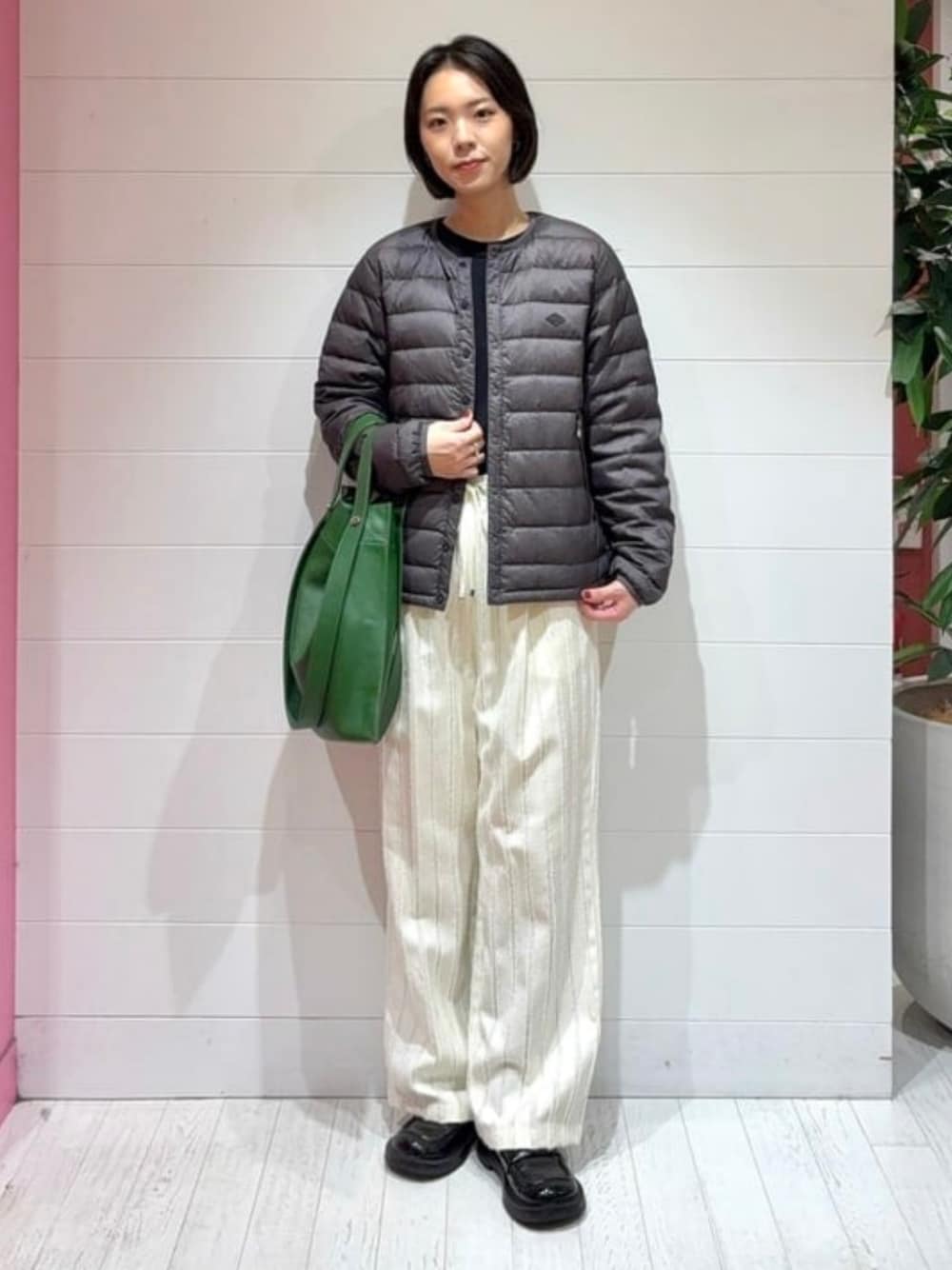 グリーン系のトートバッグ、ホワイト系のその他パンツ、ブラック系のダウンジャケット/コートを着用したレディースの秋コーディネートの1枚目の写真