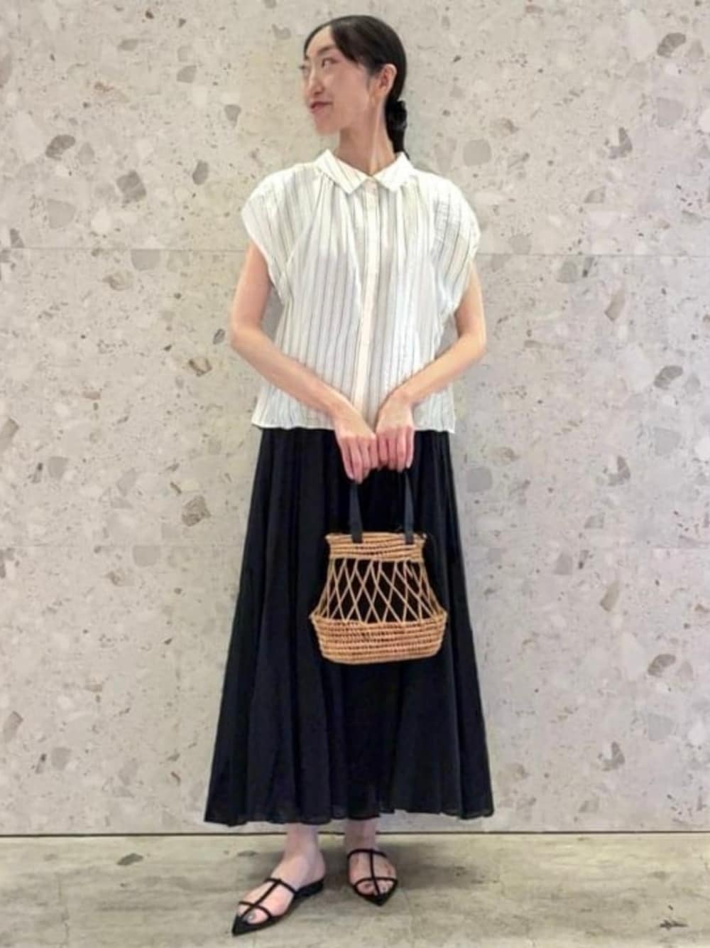 ブラック系のかごバッグ、ホワイト系のシャツ/ブラウス、ブラック系のサンダルを着用したレディースの夏コーディネートの1枚目の写真