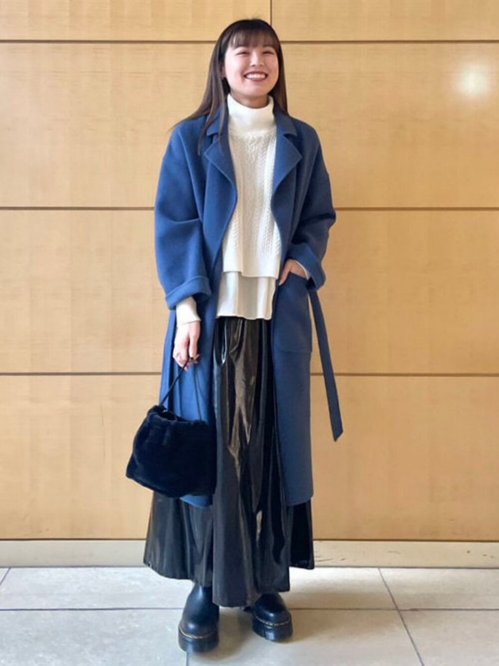 ブラック系のブーツ、ブルー系のその他アウター、ホワイト系のニット/セーターを着用したレディースの秋コーディネートの1枚目の写真