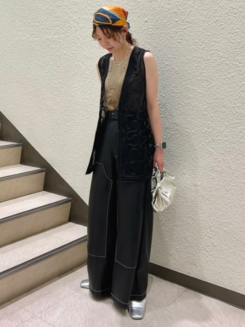 ベージュ系のタンクトップ、ブラック系のベスト、ブラック系のその他パンツを着用したレディースの春コーディネートの1枚目の写真