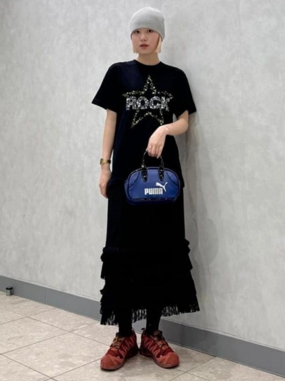 ブラック系のスカート、ブルー系のハンドバッグを着用したレディースの夏コーディネートの1枚目の写真